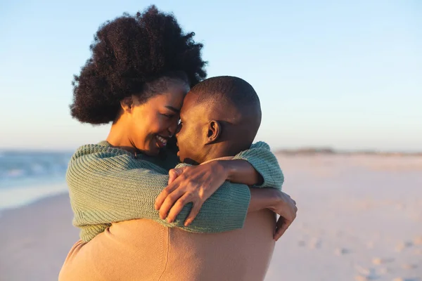 快乐的非洲裔美国夫妇在阳光灿烂的海滩上拥抱和微笑 在一起 浪漫和度假 没有改变 — 图库照片