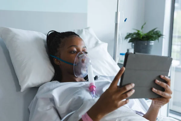 산소마스크를 아프리카 미국인 침대에 방에서 태블릿을 사용하고 있습니다 의사소통 변화없는 — 스톡 사진
