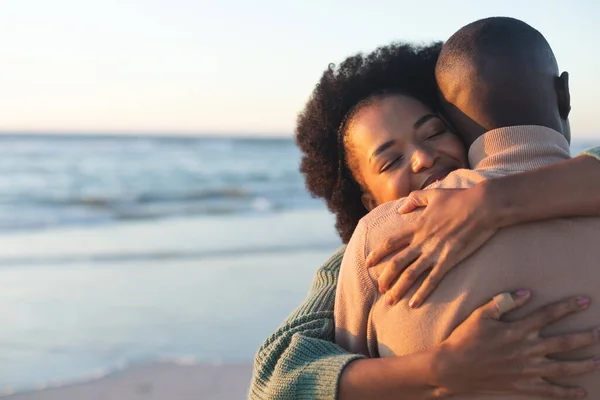 stock image Happy african american couple embracing and smiling on sunny beach, copy space. Summer, togetherness, romance and vacation, unaltered.