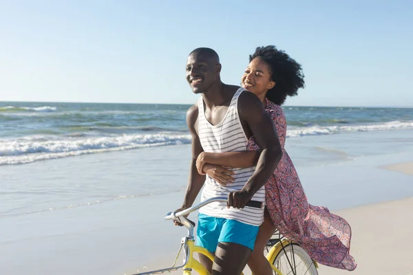 Glad Afrikansk Amerikansk Par Omfamna Ridning Cykel Solig Strand Till — Stockfoto