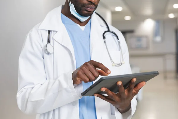 Médico Afroamericano Con Bata Laboratorio Estetoscopio Que Usa Tableta Pasillo —  Fotos de Stock