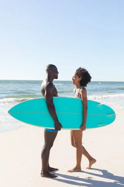 幸せなアフリカ系アメリカ人のカップルは 日当たりの良いビーチ コピースペースでお互いに笑顔サーフボードを保持 ロマンス 健康的なライフスタイル スポーツ サーフィンや休暇 変更なし — ストック写真