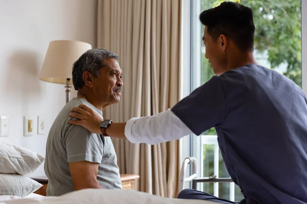 Çeşitli Erkek Doktorlar Yaşlı Erkek Hastalar Yatakta Oturup Evde Tartışıyorlar — Stok fotoğraf