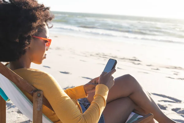 Happy African American Woman Sunglasses Sitting Deckchair Using Smartphone Sunny — Stock Photo, Image