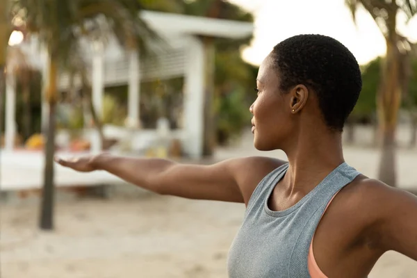 ビーチで日没時に腕を伸ばしてヨガを練習している幸せなアフリカ系アメリカ人女性 健康的なライフスタイル フィットネス 夏と休暇 変更なし — ストック写真