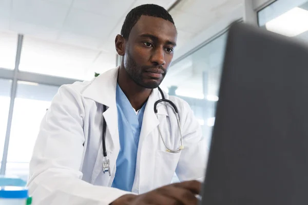 非洲裔美国医生 身穿实验室外套和听诊器 在医院使用笔记本电脑 保健和工作 — 图库照片