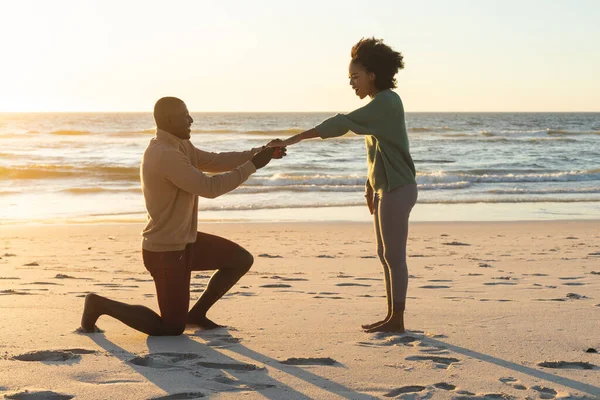 Felice Uomo Afroamericano Inginocchiato Proposto Alla Fidanzata Sulla Spiaggia Tramonto — Foto Stock