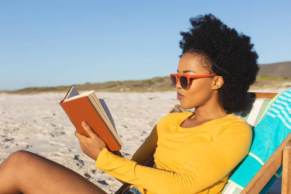 Счастливая Африканская Американка Солнечных Очках Сидящая Шезлонге Читающая Книгу Солнечном — стоковое фото