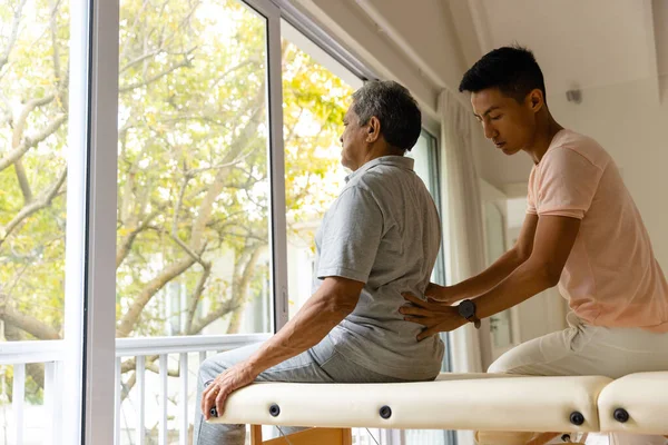 Diverso Fisioterapeuta Masculino Paciente Masculino Mayor Masajeando Espalda Fisioterapia Cuidado — Foto de Stock
