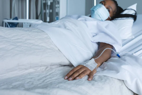 Afroamerykanka Pacjentka Masce Kapaniem Ręce Leżąca Łóżku Szpitalu Szpital Medycyna — Zdjęcie stockowe