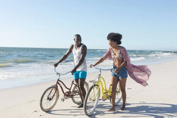 Glad Afrikansk Amerikansk Par Promenader Med Cyklar Solig Strand Till — Stockfoto