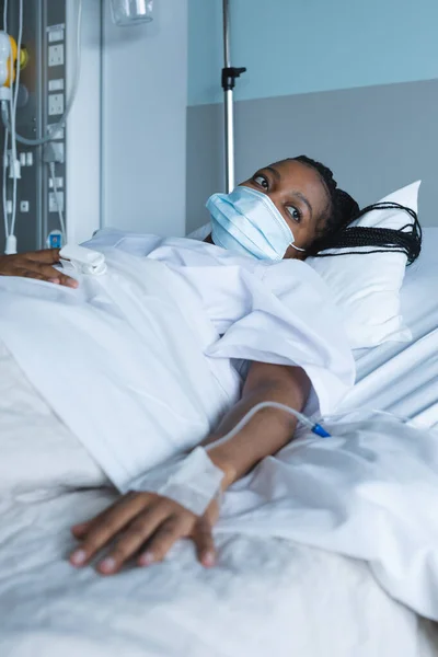 Afro Amerikaanse Vrouwelijke Patiënt Met Gezichtsmasker Wegkijkend Liggend Bed Ziekenhuiskamer — Stockfoto