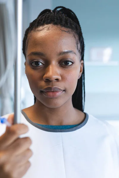 アフリカ系アメリカ人の女性患者の肖像 病院のガウンを着て 点滴を保持する 医療と仕事 変更なし — ストック写真