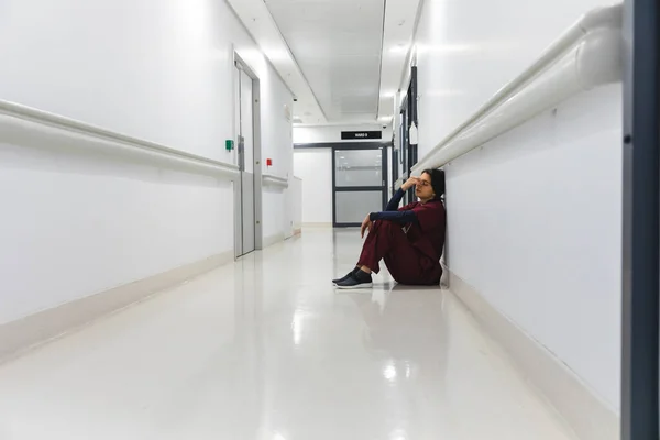 Doctora Caucásica Cansada Vistiendo Bata Sentada Suelo Pasillo Del Hospital —  Fotos de Stock