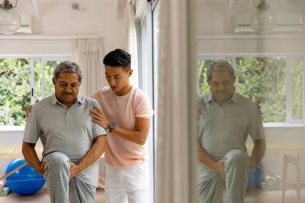 Διαφορετικός Άντρας Φυσιοθεραπευτής Συμβουλεύει Και Ανώτερος Άντρας Ασθενής Τεντώνει Πόδι — Φωτογραφία Αρχείου