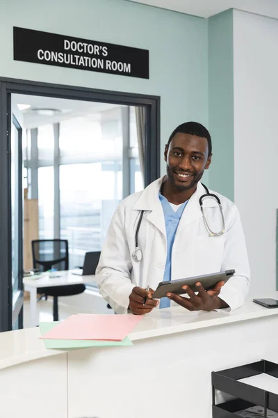 研究室のコートと聴診器を身に着けている幸せなアフリカ系アメリカ人男性医師の肖像画 ノートパソコンを保持 コミュニケーション 医療と仕事 変更なし — ストック写真