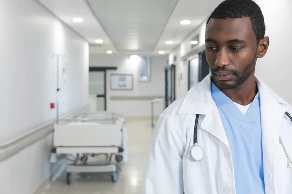 アフリカ系アメリカ人の男性医師は 研究室のコートと聴診器を着て 廊下を歩いて スペースをコピーします 医療と仕事 変更なし — ストック写真