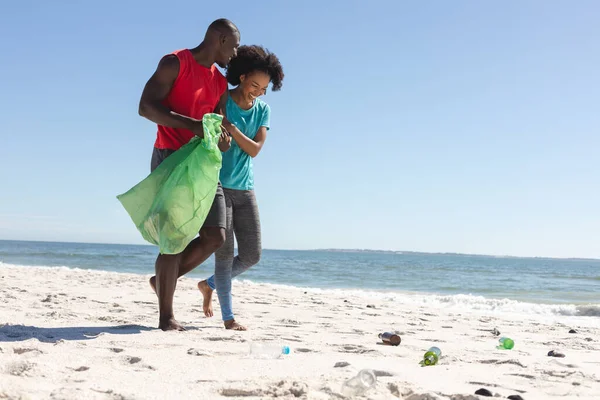 快乐的非洲裔美国夫妇清洁阳光明媚的海滩 收集垃圾 复制空间 生活方式 闲暇时间 循环利用和度假 — 图库照片