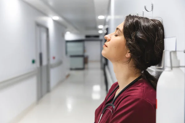 Tired Caucasian Female Doctor Wearing Scrubs Leaning Wall Corridor Hospital — Stock Photo, Image