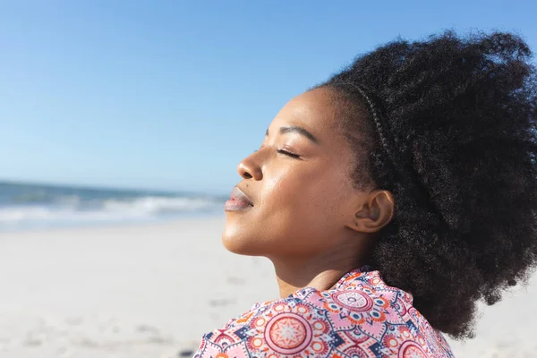 在海上阳光明媚的海滩上 松驰的非洲裔美国女人微笑着闭上了双眼 放松和假期 — 图库照片