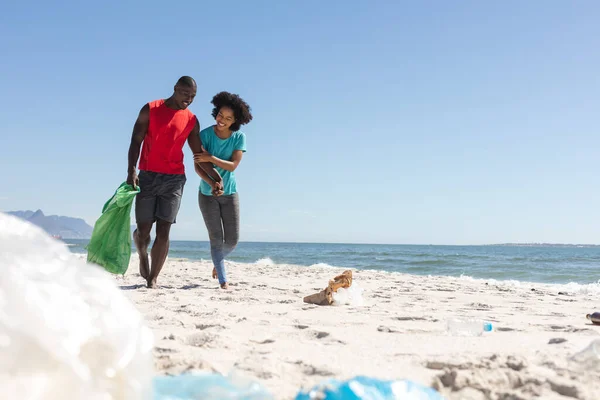 幸せなアフリカ系アメリカ人のカップルは日当たりの良いビーチを掃除し ゴミを収集し スペースをコピーします ライフスタイル 自由な時間 生態系 リサイクルと休暇 変更なし — ストック写真