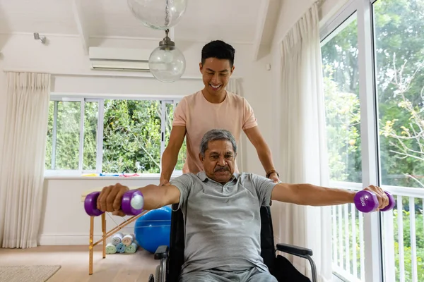 Feliz Fisioterapeuta Masculino Diverso Aconselhando Paciente Masculino Sênior Cadeira Rodas — Fotografia de Stock