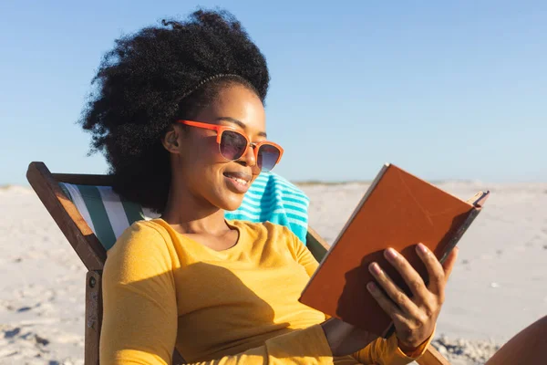 Mulher Americana Africana Feliz Óculos Sol Sentado Livro Leitura Cadeira — Fotografia de Stock