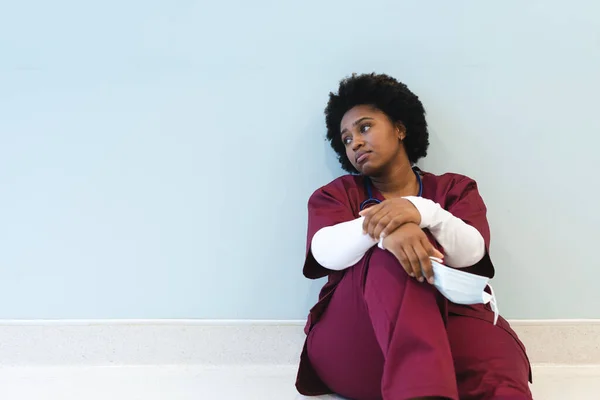 Müde Afrikanisch Amerikanische Ärztin Die Auf Dem Fußboden Krankenhausflur Sitzt — Stockfoto
