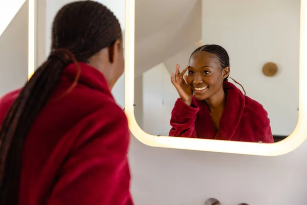 快乐的非洲裔美国女人穿着浴衣在浴室里洗脸 生活方式 卫生和家庭生活 — 图库照片