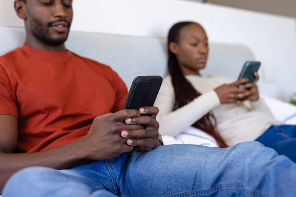 非洲裔美国人夫妇使用智能手机躺在床上卧室里 生活方式 沟通和家庭生活 — 图库照片