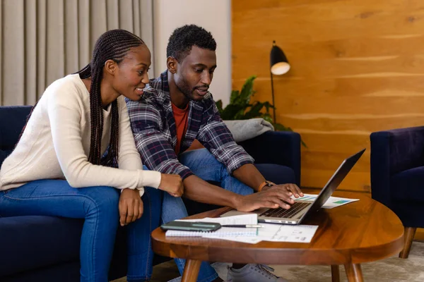 幸せなアフリカ系アメリカ人のカップルは自宅でノートパソコンを使って書類作成をする ライフスタイル コミュニケーション 国内生活 変わらない — ストック写真