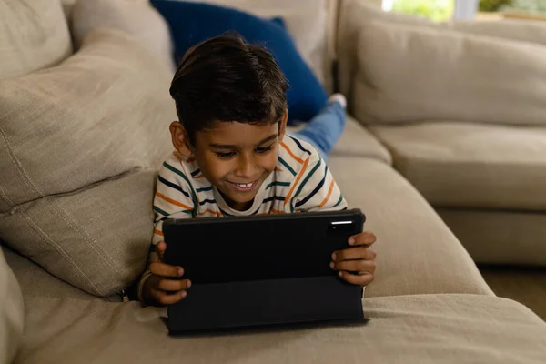 Boldog Biracial Fiú Feküdt Kanapén Táblagéppel Nappaliban Gyermekkor Szabadidő Technológia — Stock Fotó