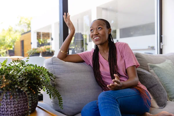 幸せなアフリカ系アメリカ人女性がリビングルームでビデオ通話をしています ライフスタイル コミュニケーション 国内生活変更なし — ストック写真