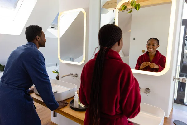 Gelukkig Afrikaans Amerikaans Echtpaar Badjassen Die Spiegel Kijken Badkamer Lifestyle — Stockfoto