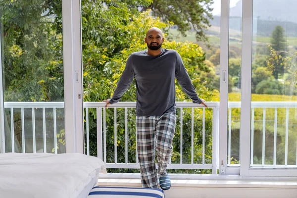 Portrait Happy Biracial Man Pyjamas Standing Balcony Bedroom Treetops Background — Stock Photo, Image