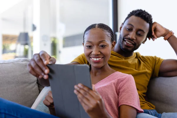 Mutlu Afro Amerikan Çifti Gülümseyip Kucaklaşıyorlar Evdeki Kanepede Tablet Kullanıyorlar — Stok fotoğraf