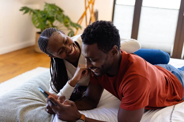Šťastný Africký Americký Pár Pomocí Smartphonu Ležící Posteli Ložnici Relaxace — Stock fotografie