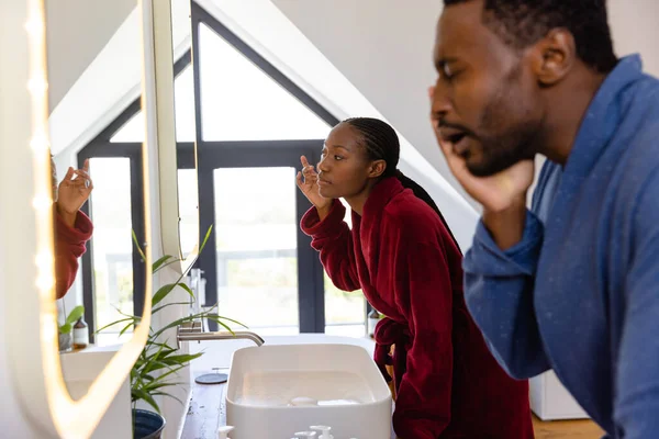 Afro Amerikaans Stel Badjassen Kijkend Spiegel Badkamer Lifestyle Hygiëne Huishoudelijk — Stockfoto