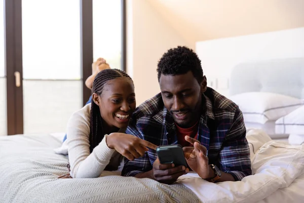 Gelukkig Afrikaans Amerikaans Echtpaar Met Behulp Van Smartphone Liggend Bed — Stockfoto
