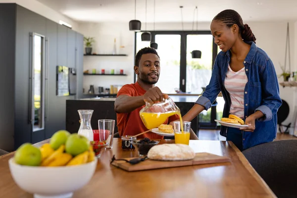 幸せなアフリカ系アメリカ人のカップルのダイニングルームで朝食を提供しています ライフスタイル 団結と国内生活 変更されない — ストック写真