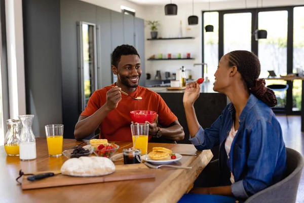 幸せなアフリカ系アメリカ人のカップルがダイニングルームで朝食を楽しんでいます ライフスタイル 団結と国内生活 変更されない — ストック写真