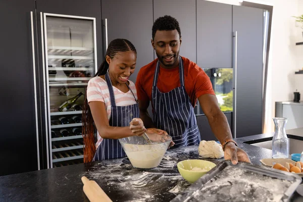 快乐的非洲裔美国夫妇 穿着围裙在厨房准备面包面团 生活方式 结合和家庭生活 — 图库照片