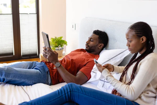 Casal Afro Americano Usando Tablet Smartphone Deitado Cama Quarto Relaxamento — Fotografia de Stock