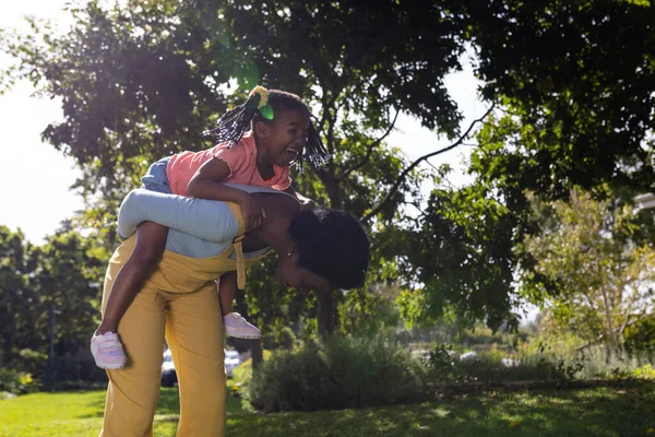 Afrikai Amerikai Játékos Anya Malackodó Lánya Miközben Hajlik Fák Parkban — Stock Fotó