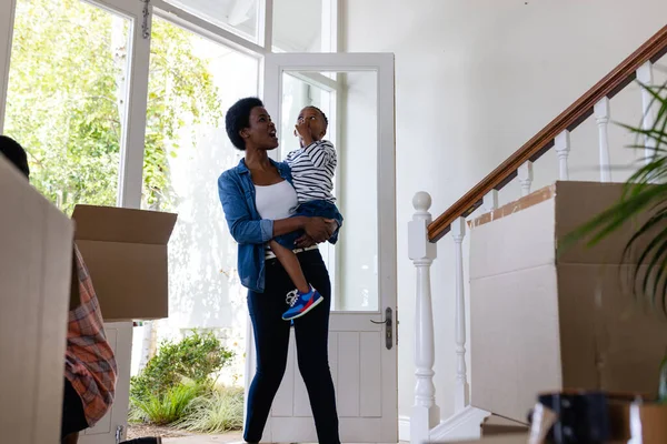 アフリカ系アメリカ人の母親は息子を連れて新しい家の入り口に立っている 変化のない家族愛子供時代引越しのコンセプト — ストック写真