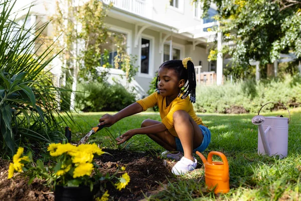 外の庭の芝生の土地に道具で土を掘るアフリカ系アメリカ人の少女 変更されていない ライフスタイル ガーデニング 自然と子供時代のコンセプト — ストック写真