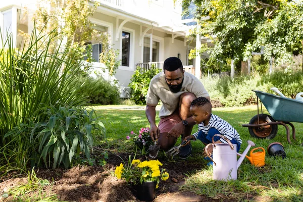 非裔美国人的父亲和儿子在后院挖泥土种花 不变的生活方式 周末和童年的概念 — 图库照片