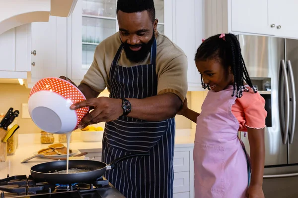 快乐的非洲裔美国父亲 女儿在厨房的平底锅里做煎饼 不变的生活方式 学习和家庭观念 — 图库照片