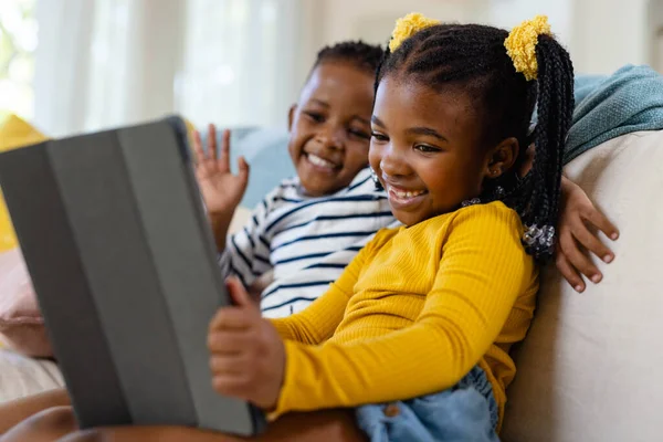 非洲裔美国人快乐的兄弟姐妹坐在客厅的沙发上 一边用数字平板电脑 不变的家庭 生活方式 科技和家庭观念 — 图库照片