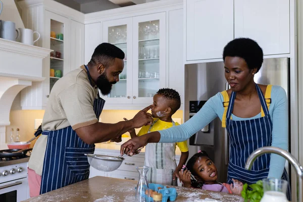 非洲裔美国人快乐的父母和孩子们在厨房的岛上玩面粉 不变的生活方式 准备和学习 — 图库照片